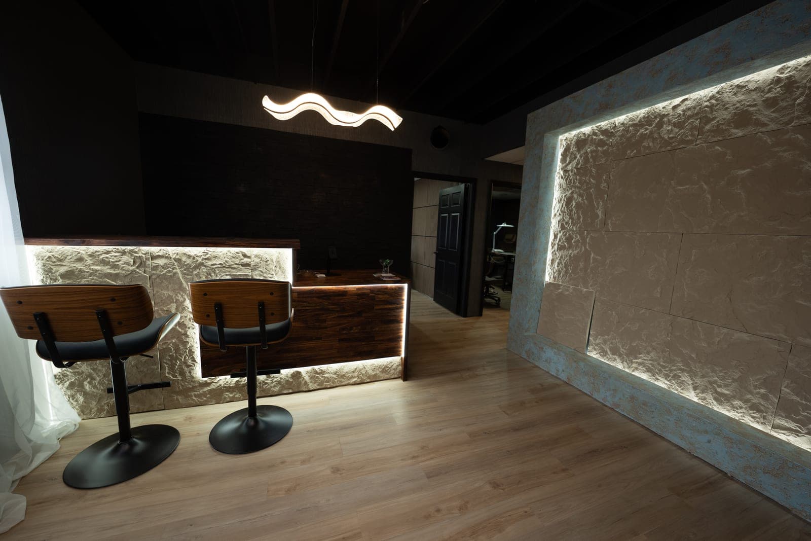 Reception at Like No Other Boutique: a backlit stone desk under a ribbon of light